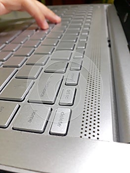 silver laptop keyboard being used for work photo