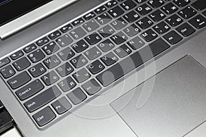 Silver laptop keyboard and touchpad, close-up view