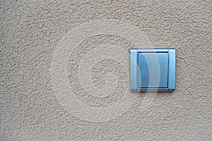 Silver light switch on yellow outdoor wall