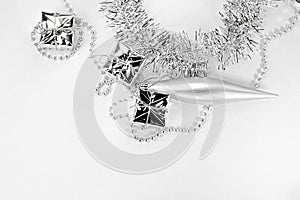 Silver long toy, little gifts, chain with balls, beads, shiny tinsel. New year decorations on a white background. Christmas