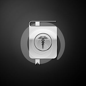 Silver Medical book and Caduceus medical icon isolated on black background. Medical reference book, textbook