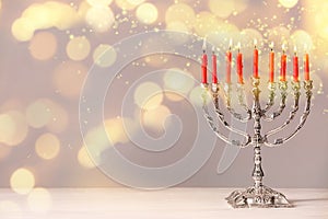 Silver menorah with burning candles on table against light background, space for text. Hanukkah celebration