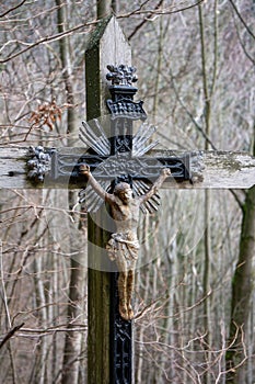 Silver metal cross featuring a crucifix symbol in the center