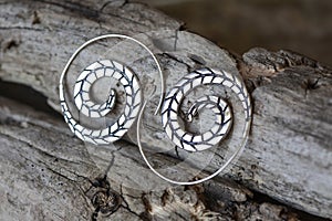 Metal decorative oriental spirale design earrings on natural neutral background photo