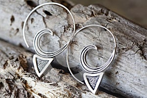 metal decorative oriental spirale design earrings on natural neutral background photo