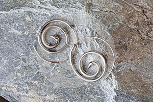 metal decorative oriental spirale design earrings on natural neutral background photo