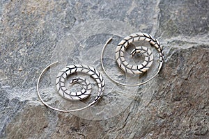 Metal decorative oriental spirale design earrings on natural neutral background