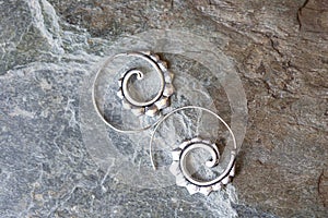 Metal decorative oriental spirale design earrings on natural neutral background