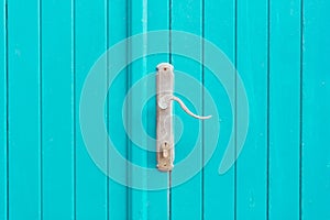 Silver metal door handle on a blue doors.