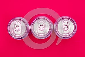 Silver metal energy drinks cans on pink background