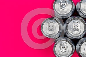 Silver metal energy drinks cans on pink background