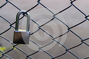 Silver metal lock sticked on grate fence.