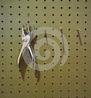 Silver metal staple remover hanging on wooden pin