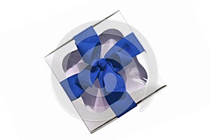 Silver metallic gift box with a blue ribbon bow isolated on white background. Copy space, mockup, flatlay, top view
