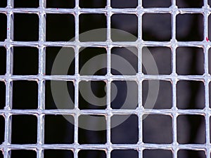 Silver metallic grating of squares on a black background
