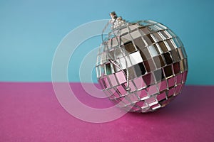 Silver mirror musical club disco ball xmas festive Christmas ball, Christmas toy plastered on glitter gray pink purple background