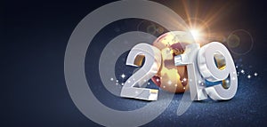 Silver New Year date 2019 composed with a gold planet earth, sun shining behind, on a glittering black background - 3D
