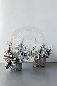 Silver New Year`s flower arrangement of Christmas tree branches and candles for a gift. New Year`s decor for the interior