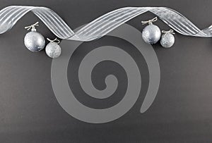 Silver Ornaments and Ribbon on Black Slate Background