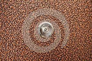 Silver peephole in brown iron door