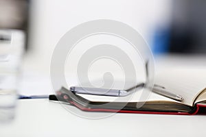 Silver pen lying on opened notebook sheet closeup