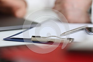 Silver pen lying on opened notebook sheet closeup