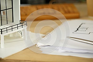 Silver pen lying at working table of architect with blueprints