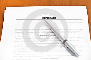 Silver pen on sheet of sales contract on table