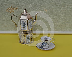 English teacup, saucer, silver-plated teapot on a silver stove, with floral decor