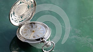 Silver pocket watch close up on turquoise marble background