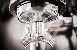 Silver portafilter connected to coffee machine