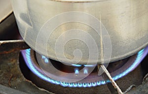 Silver pot boiled on fire gas stove in kitchen