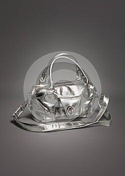 Silver purse/handbag made of leather on gradient gray background