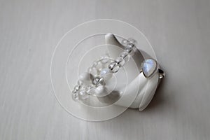 Silver ring with moonstone and bracelet from rock-crystal on porcelain hand.