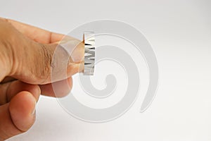 Silver ring of a unique design used as a fashion jewelry held in the hand on a white background