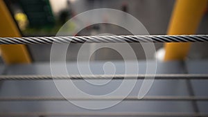 silver rope. Close-up of thick metal rope diagonally attached to balcony railing, Selective focus