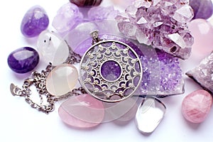 Silver round pendant and chain on semi-precious stones. Silver jewelry and druze of amethyst, rock crystal and rose quartz on a