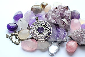 Silver round pendant and chain on semi-precious stones. Silver jewelry and druze of amethyst, rock crystal and rose quartz on a