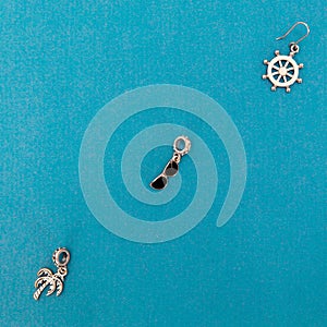 Silver sea-style pendants on a blue background. Modern costume jewelry. Top view