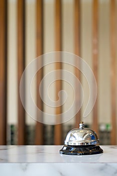 Silver service bell on hotel reception desk. Close up