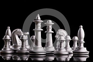 Silver set chess pieces on a black
