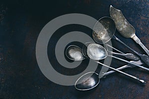 Silver set of vintage cutlery on a dark background, top view