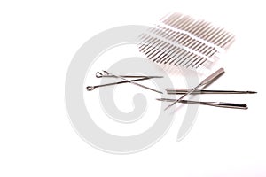 Silver sewing pins and needles on white background