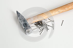 Silver shiny iron nails with hammer on white background