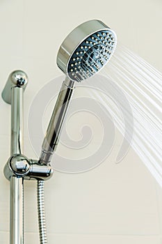 Silver shower head in bathroom with water drops flowing, Bathroom equipment