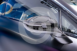Silver side view mirror with silver modern car. Close up.