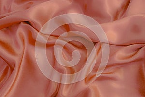 Silver silk background. Orange.Folds