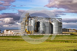 Silver silos and modern granary elevator and seed cleaning line on agro-processing and manufacturing plant for storage and