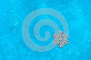 Silver snowflake on a blue grunge background. Minimal Christmas composition. Top view, flat lay