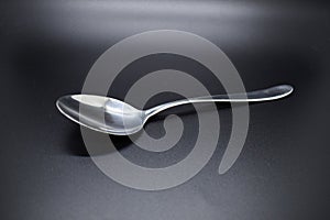 Silver spoon set against dark background